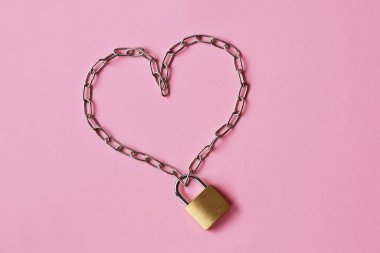 Pembe arka planda asma kilit olan kalpten yapılmış aşk ve özgürlük kavramı