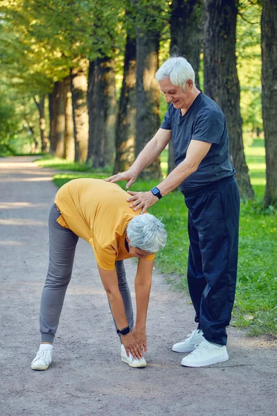 高齢者の夫婦は 屋外で演習を行うに動作します 健康的なスポーツライフスタイルや退職者のコンセプト — ストック写真