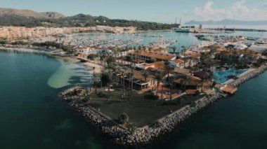 Drone point of view Port of Alcudia town. Aerial shot of townscape and Mediterranean Seascape in the tourist resort of Majorca during sunny day. Travel and tourism concept. Balearic Island. Spain