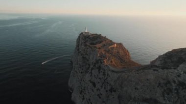 Drone point of view to The Formentor Lighthouse on rocky mountains top surrounded by waters of Mediterranean Seascape. Balearic Islands. Spain