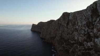 Drone point of view to The Formentor Lighthouse on rocky mountains top surrounded by waters of Mediterranean Seascape. Balearic Islands. Spain