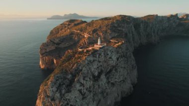 Drone point of view to The Formentor Lighthouse on rocky mountains top surrounded by waters of Mediterranean Seascape. Balearic Islands. Spain