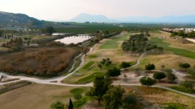 Tipik İspanyol golf sahaları ve evleri. Golf sporu için yeşil çimenler, palmiye ağaçları ve göller. Yeşil alan, tropikal iklim, hava aracı bakış açısı. Alicante vilayeti. Costa Blanca 'da. İspanya