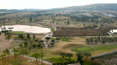 Tipik İspanyol golf sahaları ve evleri. Golf sporu için yeşil çimenler, palmiye ağaçları ve göller. Yeşil alan, tropikal iklim, hava aracı bakış açısı. Alicante vilayeti. Costa Blanca 'da. İspanya