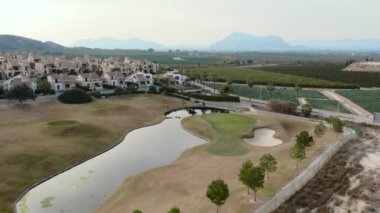 Tipik İspanyol golf sahaları ve evleri. Golf sporu için yeşil çimenler, palmiye ağaçları ve göller. Yeşil alan, tropikal iklim, hava aracı bakış açısı. Alicante vilayeti. Costa Blanca 'da. İspanya