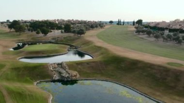 Tipik İspanyol golf sahaları ve evleri. Golf sporu için yeşil çimenler, palmiye ağaçları ve göller. Yeşil alan, tropikal iklim, hava aracı bakış açısı. Alicante vilayeti. Costa Blanca 'da. İspanya