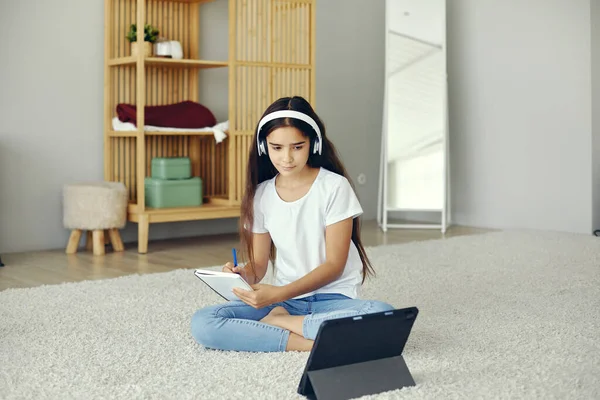 プリティーティーン12Sの女の子は ワイヤレスヘッドフォンを着用し 床に座って デジタルタブレットを使用して家庭教育 オーディオコースの勉強を聞く Eラーニング ジェンZのための現代的な技術の使用新しいスキルを獲得 — ストック写真
