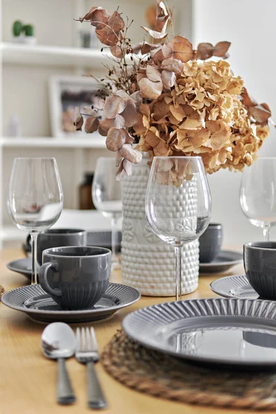 餐桌上放着漂亮的花朵 上面放着咖啡或茶杯和茶碟 准备好迎接客人或家人的早餐 近距离拍摄 没有人 — 图库照片