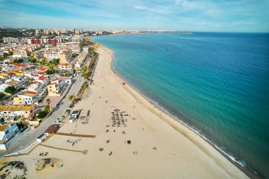 Hava görüntüsü, Mil Palmeras 'ın kumlu kıyı şeridi, kumlu plaj ve güneşli bir günde modern bina çatısı. Costa Blanca, Alicante ili. İspanya