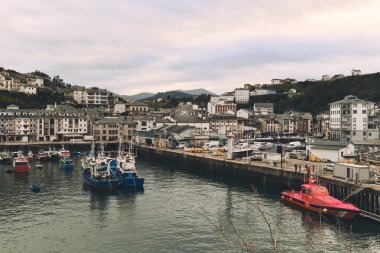 Bulutlu kış gününde Luarca Limanı 'ndaki demirli teknelere gündüz görüşü. İspanya 'nın kuzeyinde, Asturias' ın Valdes belediyesinin ana kasabası. Seyahat yerleri ve turistik yerler kavramı