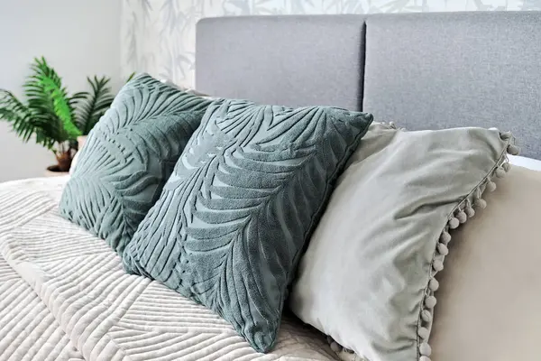 在舒适的卧室里 把三个绿色的垫子放在床上 没有人 放松和度假概念 — 图库照片