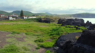 Ponta Delgada, Azores 'deki manzarada volkanik kaya oluşumları, yemyeşil alanlar ve dramatik uçurumlar ve Atlantik manzaralarıyla harmanlanmış siyah kumlar yer alıyor.