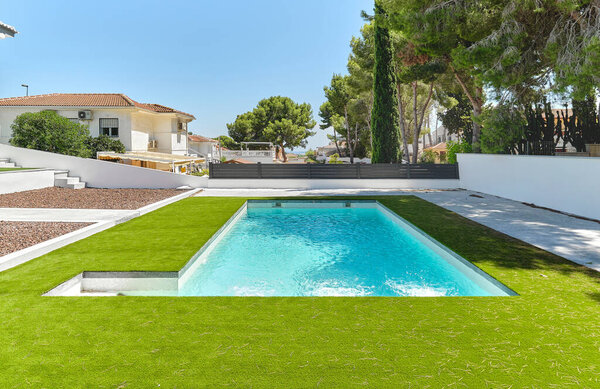 Green lawn with swimming pool. Modern architecture summer pleasure, travel concept. Alicante, Costa Blanca, Spain