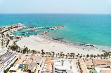 Torre de la Horada plajı, yukarıdan manzara. Güneşli bir günde deniz kenarına insansız hava aracı ve konut evleri çatıları. Costa Blanca, Alicante, İspanya. Seyahat ve tatiller