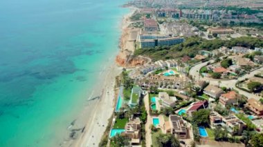 Orihuela Costa 'daki Dehesa de Campoamor köyünde hava saldırısı. Yeşilliklerle çevrili evler, sahil kenarındaki apartmanlar, kumlu sahil, Akdeniz manzaralı evler. İspanya