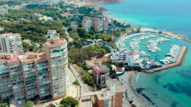 İHA bakış açısına göre İspanyol turistler güneşli yaz günlerinde Dehesa de Campoamor köyü manzarasına, liman manzarasına, kıyı gökdelenlerine ve Akdeniz manzarasına sahipler. Costa Blanca 'da. İspanya