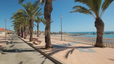 Torre de la Horada, İspanya - 22 Eylül 2024: İnsanlar güneşli yaz gününde Torre de la Horada 'da deniz kenarında gezinti yapıyorlar. Costa Blanca 'da. Alicante vilayeti. Güney İspanya. Turizm konsepti