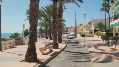 Torre de la Horada, İspanya - 22 Eylül 2024: İnsanlar güneşli yaz gününde Torre de la Horada 'da deniz kenarında gezinti yapıyorlar. Costa Blanca 'da. Alicante vilayeti. Güney İspanya. Turizm konsepti