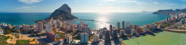 Panorama manzaralı Calpe kıyı kasabası. Akdeniz 'deki Penon de Ifach kayası ile kıyı şeridine hava aracı bakış açısı, modern yüksek binalar. Popüler turizm merkezi. Costa Blanca 'da. İspanya