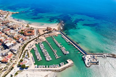 İspanya 'nın Torre de la Horada kıyı kasabasının çatıları, Akdeniz' in turkuaz körfezi ve güneşli bir günde teknelerle dolu limanı vardır. Costa Blanca, Alicante vilayeti. İspanya