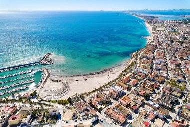 İspanya 'nın Torre de la Horada kıyı kasabasının çatıları, Akdeniz' in turkuaz körfezi ve güneşli bir günde teknelerle dolu limanı vardır. Costa Blanca, Alicante vilayeti. İspanya