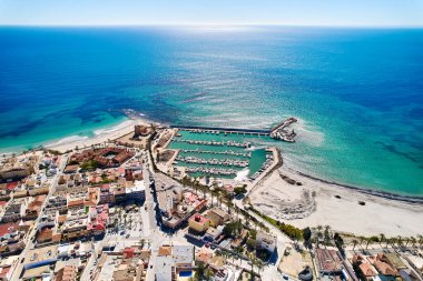 İspanya 'nın Torre de la Horada kıyı kasabasının çatıları, Akdeniz' in turkuaz körfezi ve güneşli bir günde teknelerle dolu limanı vardır. Costa Blanca, Alicante vilayeti. İspanya