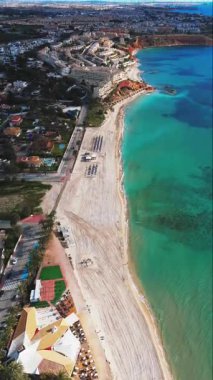 Dehesa de Campoamor tatil köyünün havadan görünüşü. Kızıl kayalıklar, palmiye ağaçları, villalar ve altın kumlu plajlarla kaplı turkuaz Akdeniz ile karşılaşıyor. Alicante ili, İspanya. Costa Blanca