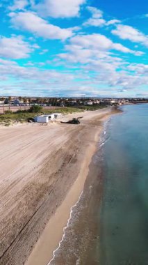 Torre de la Horada, İspanya 'daki sakin sahilin havadan görünüşü, altın kum, berrak turkuaz sular, yumuşak dalgalar ve kıyı bitkileri.
