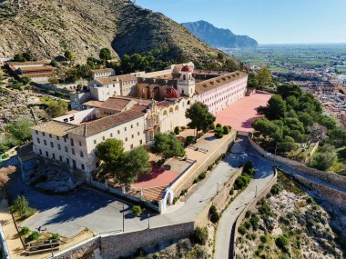 Virajlı yolun havadan görünüşü İspanya 'nın Orihuela kasabasına tepeden bakan engebeli tepenin tepesinde San Miguel Diocesan Papaz Okulu' na çıkıyor. Costa Blanca, Alicante vilayeti