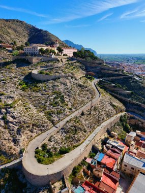 Virajlı yolun havadan görünüşü İspanya 'nın Orihuela kasabasına tepeden bakan engebeli tepenin tepesinde San Miguel Diocesan Papaz Okulu' na çıkıyor. Costa Blanca, Alicante vilayeti