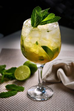 Modern masa düzeninde buzlu, naneli ve limonlu mojito kokteyli.
