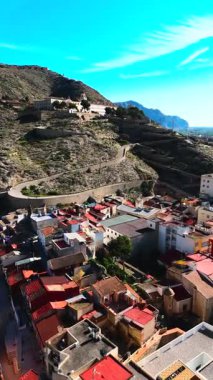 Virajlı yolun havadan görünüşü İspanya 'nın Orihuela kasabasına tepeden bakan engebeli tepenin tepesinde San Miguel Diocesan Papaz Okulu' na çıkıyor. Costa Blanca, Alicante vilayeti