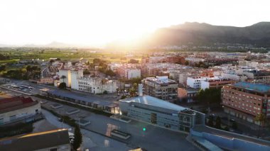 Orihuela 'nın hava manzarası, modern alışveriş merkezi olan şehir, parlak mavi gökyüzünün altındaki dağlar. İspanya, Costa Blanca