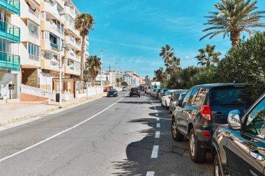 Torrevieja, İspanya - 28 Eylül 2024: Torrevieja 'da güneşli bir gün. Palm-line caddesine bak, konut binaları var, tipik Akdeniz kıyı kasabası, Costa Blanca sahil beldesi. İspanya