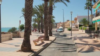 Torre de la Horada, İspanya - 22 Eylül 2024: İnsanlar güneşli yaz gününde Torre de la Horada 'da deniz kenarında gezinti yapıyorlar. Costa Blanca 'da. Alicante vilayeti. Güney İspanya. 