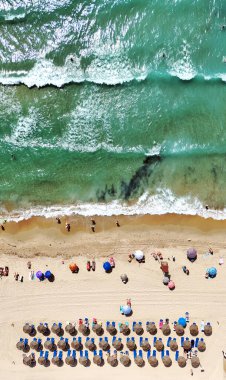 Costa Blanca 'daki Dehesa de Campoamor plajının havadan görüntüsü. Saman şemsiyeler, kumlu kıyı şeridi, turkuaz Akdeniz. Yaz tatilleri, seyahatler, turizm, kıyı rahatlığı. Alicante ili, İspanya