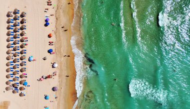 Costa Blanca 'daki Dehesa de Campoamor plajının havadan görüntüsü. Saman şemsiyeler, kumlu kıyı şeridi, turkuaz Akdeniz. Yaz tatilleri, seyahatler, turizm, kıyı rahatlığı. Alicante ili, İspanya