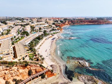 Kosta Blanca 'nın başkenti Alicante' de bulunan Dehesa de Campoamor ve Cabo Roig 'in turkuvaz suları ve modern konutlarıyla sakin bir Akdeniz sahili manzarası. İspanya