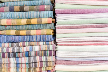 Katlanmış kumaşların canlı tonlarda dizilimi tasarım ve renk çeşitliliğini gösterir.