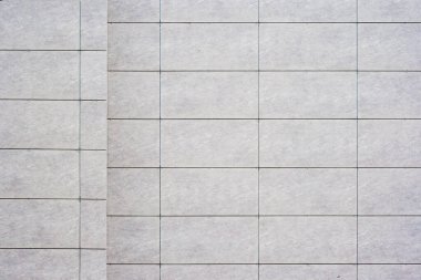 Izgara desenli, açık gri kiremitler ve koyu harç çizgilerinin yer aldığı, dokusu, arkaplanı olan fayanslı bir duvarı kapat..