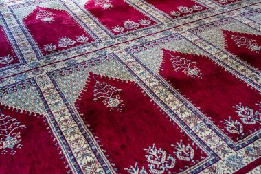 Türkiye 'de bir camide, karmaşık tasarımları olan geleneksel kırmızı ve beyaz desenli bir halıyı kapatın.