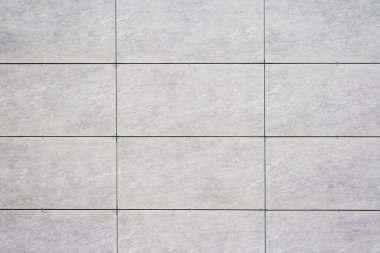 Izgara desenli, açık gri kiremitler ve koyu harç çizgilerinin yer aldığı, dokusu, arkaplanı olan fayanslı bir duvarı kapat..