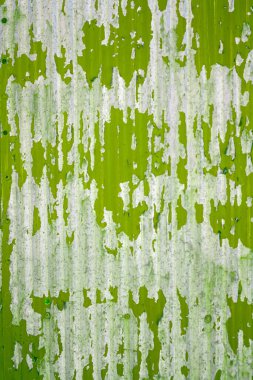 Yıpranmış metal bir yüzeye yakın, yeşil boyayla soyulmuş, paslanmış ve aşınmış..