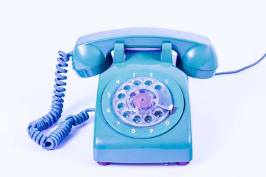 Beyaz arka planda, sarmalanmış kablosu olan klasik turuncu bir çevirmeli telefon, stüdyo çekimi..