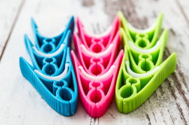 Kırsal bir ahşap yüzeyde mavi, pembe ve yeşil desenli renkli kumaşlar günlük ev eşyalarına neşe katıyor..