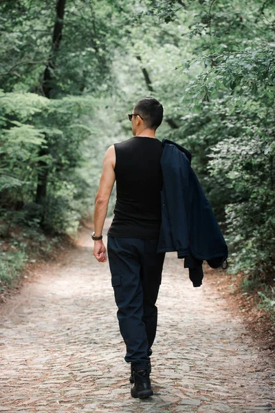 Uomo Brutale Abiti Neri Cammina Lungo Vicolo Nella Foresta Nebbiosa — Foto Stock