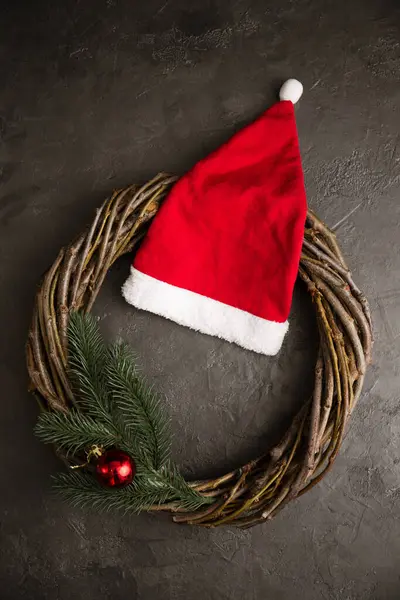 Венок Ветвей Красная Шляпа Санта Клауса Сером Фоне Концепция Рождества — стоковое фото