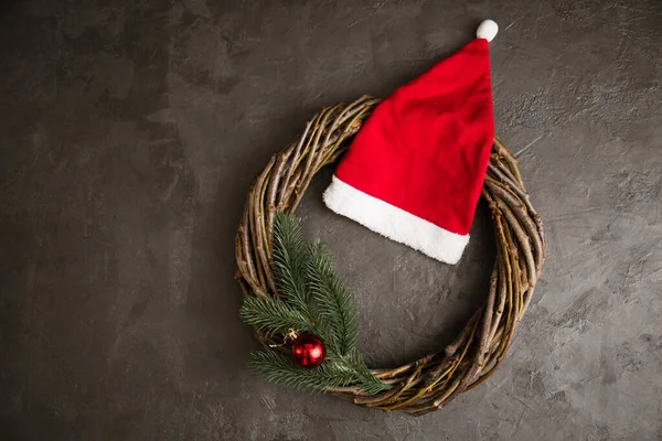 Венок Ветвей Красная Шляпа Санта Клауса Сером Фоне Концепция Рождества — стоковое фото