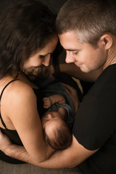 Jonge Ouders Met Hun Kleine Baby Een Donkere Achtergrond Van — Stockfoto