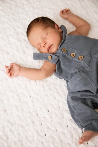 stock image A small newborn boy is sleeping on a white soft blanket